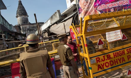 A police officer checks identity papers at a security barricade in Ayodhya