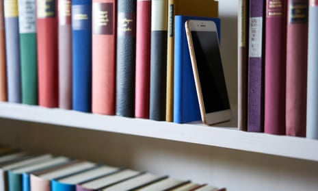 Mobile phone in bookshelf between various books