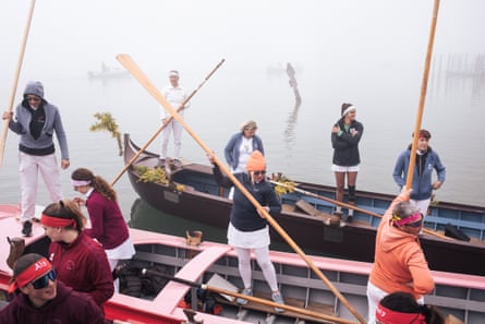 Gondoliers holding their remos in the foggy air as they prepare their gondolas