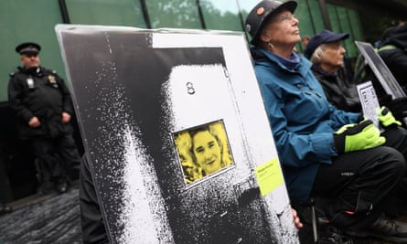 Protesters hold placards bearing images of Phoebe Plummer