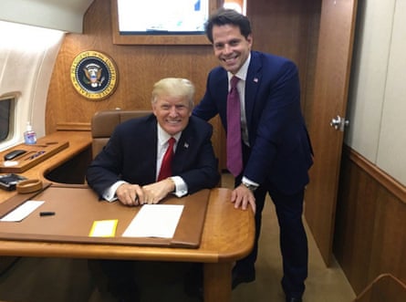 Anthony Scaramucci standing next to Donald Trump, who is sitting at a desk, inside an aircraft