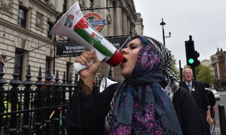 Pro-Palestinian protester holds a megaphone ahead of a march in support of the Palestinian people in Gaza, in London, Saturday, April 27, 2024.