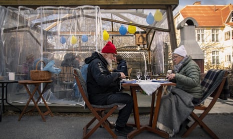 An older couple eat dinner while keeping distance from the rest of their family on 18 April in Ostersund, Sweden.