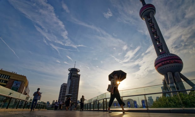 Residents using umbrellas to shield themselves from the sun in Shanghai, China.