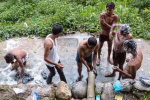 Late in the evening men gather at a spring for their daily bathing.