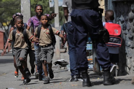 Schoolchildren run for cover amid gang violence in Port-au-Prince, Haiti 3 March 2023.