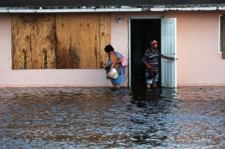 A couple leave their flooded home the morning after Hurricane Irma swept through the area in September 2017 in Fort Myers, Florida.