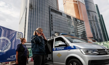 Police officers stand outside a damaged building in the Moscow-City business center after a drone reportedly fell.
