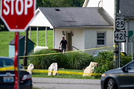 police officer stands outside of church blocked off by caution tape