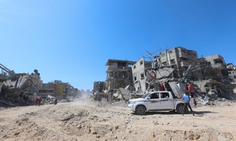 Palestinian people inspect destroyed residential buildings in Khan Younis.