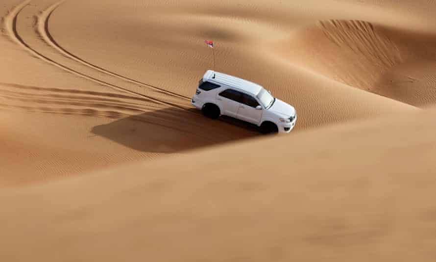 Un hombre conduce su automóvil en el desierto cerca de Sharjah, Emiratos Árabes Unidos, 25 de junio de 2021.