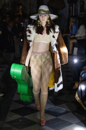 A model carries a 'Gucci band' guitar case.