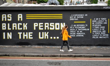 A woman walks past a street art piece by Lanie Rose in the Stokes Croft area of Bristol.