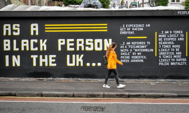 A woman walks past a street art piece by Lanie Rose in Bristol