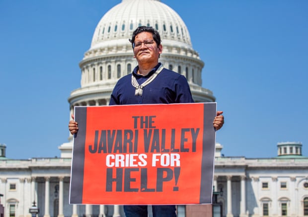 man holds sign saying 'the javari valley cries for help!' in front of Capitol