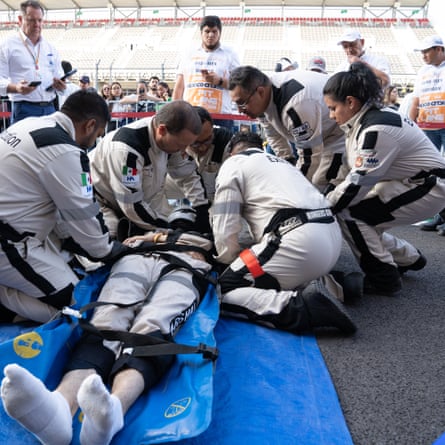 The extrication team carry out a rehearsal to remove a driver from a car, while the supporting firefighters and medical staff observe at the Mexican Grand Prix.