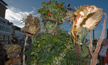 The Holly Man holds up the crowns for King Bean and Queen Pea, Bankside, London