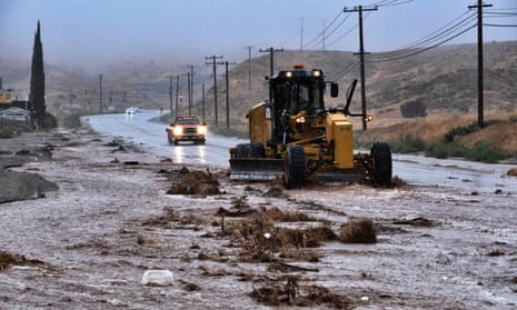 A plow clears debris along a flooded Sierra Highway in Palmdale, California.