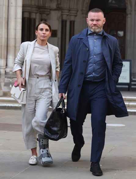 The couple leaving the Royal Courts of Justice, London, in 2022 during the Wagatha Christie trial. She is in all grey and he is in varying shades of blue and carrying a large tote bag