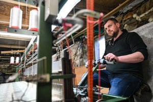 MacLeod standing beside a loom in his workshop