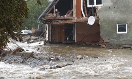 Flood waters and a badly damaged house eiqrkixuiddprw