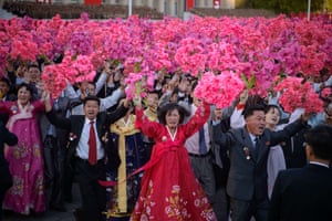 Participants wave flowers at North Korean leader Kim Jong-Un