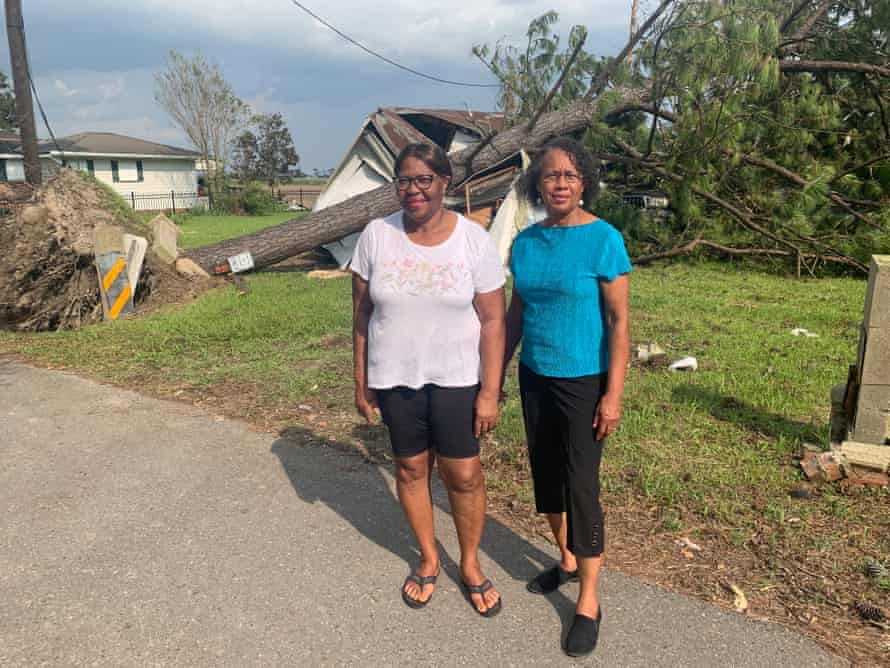 Myrtle Felton and Barbara Washington stand in front of damage caused by Hurricane Ida.