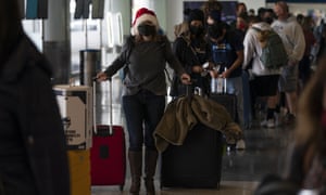 A woman waits in line to check in for her flight to Washington at Los Angeles international airport as thousands of travellers’ Christmas plans are dashed amid ongoing flight cancellations