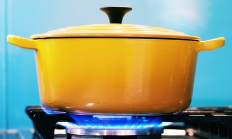 Yellow lidded pot steaming on lit gas stove