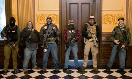 A militia group, including Pete Musico, right, who was charged over a plot to kidnap the Michigan governor, attack the state capitol building and incite violence, stands in front of the governors office after protesters occupied the state capitol building in Lansing, Michigan, on 30 April 2020.
