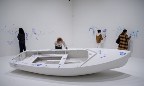 Gallery assistants pose with a participatory installation entitled Add Colour (Refugee Boat) during the press preview of Yoko Ono: Music of the Mind exhibition at Tate Modern in London on 13 February 2024.