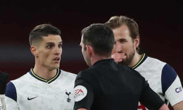 Erik Lamela protests to Michael Oliver after being shown the red card while Harry Kane covers his mouth to prevent lipreading as he talks to the referee