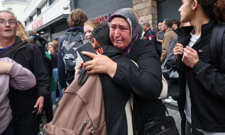 A pupil is comforted by a relative as he leaves the school.