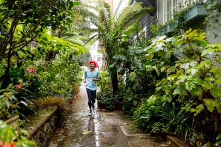 Frank Chan running on a path surrounded by lush vegetation