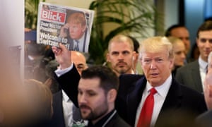 Donald Trump holds up Swiss newspaper Blick as he arrives at the Congress Centre in Davos on Friday.