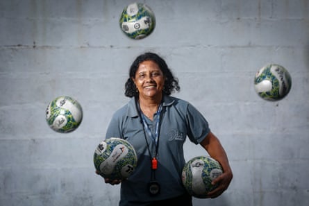 Dilma Mendes smiles while holding two footballs.