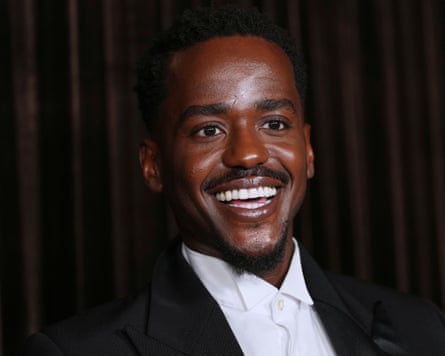 Gatwa smiles, posing in a black suit and white shirt at an awards event