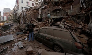 Wounded people sit on a street following an explosion in the Lebanese capital Beirut on 4 August 2020.