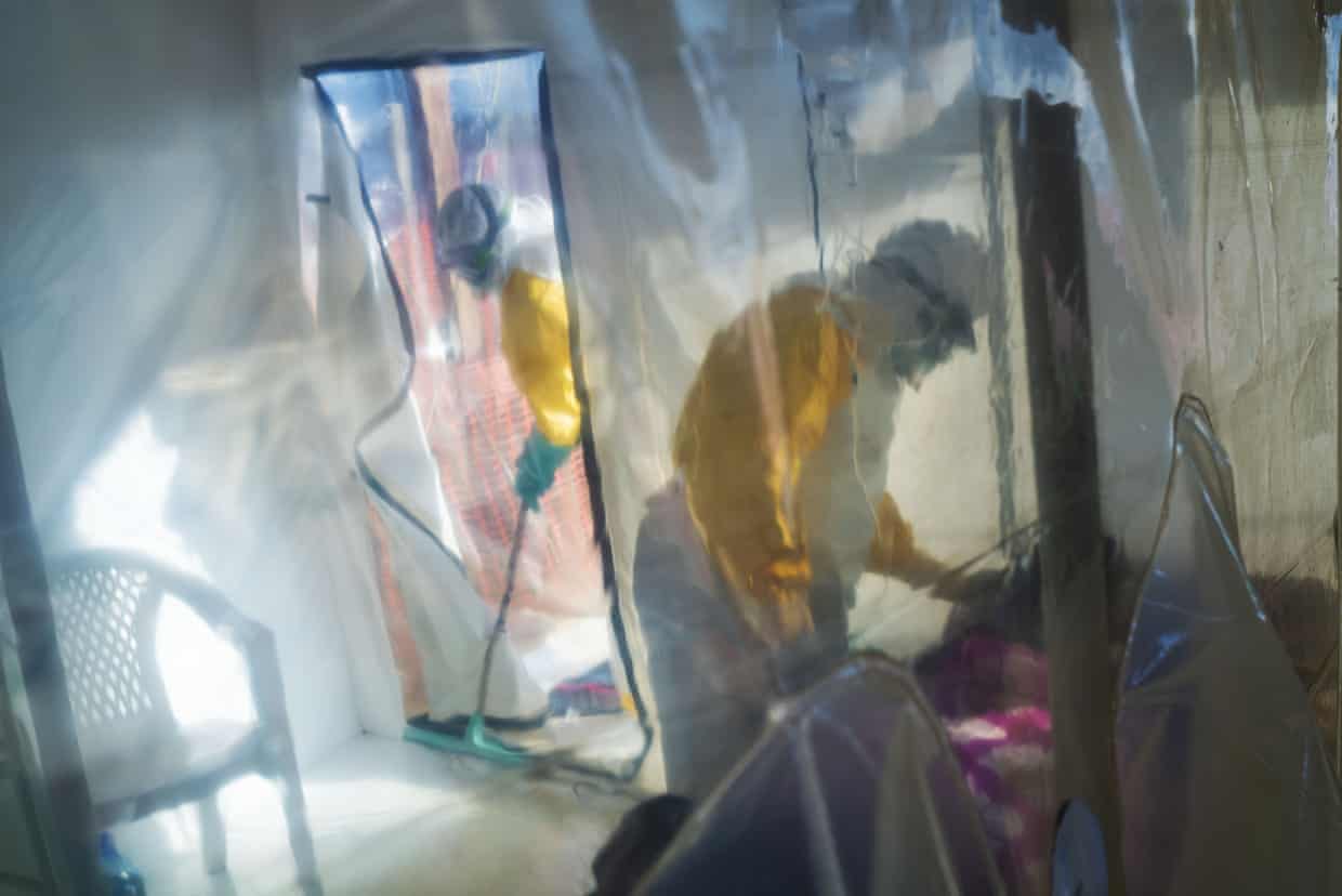 Health workers in protective suits in an isolation unit