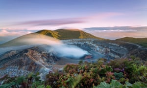 High angle view of Poas volcano crater emitting smoke at sunset, Costa Rica.