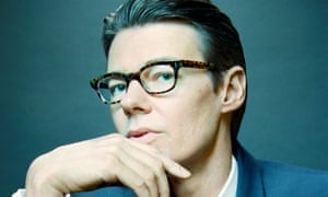 Andrew Bolton portrait: head slightly to one side, in heavy-rimmed glasses, hand lightly on his chin