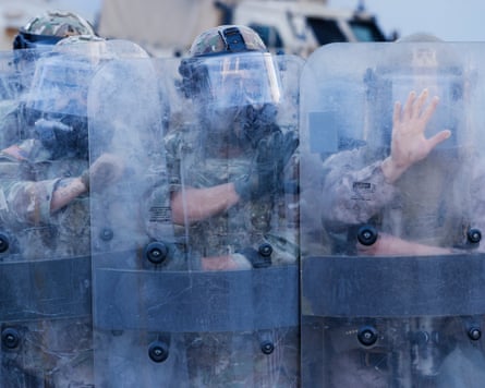 Marines and National Guard stand guard as Angelenos rally against ICE raids taking place in the city, 4 July 2025.