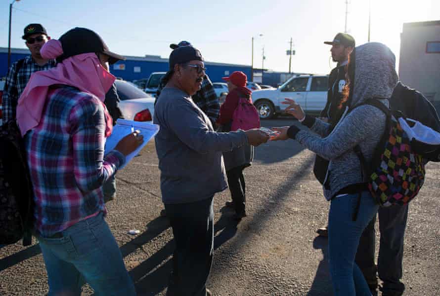 A temporary agricultural worker gets a daily advance on her paycheck after getting off a bus at the port of entry in San Luis, Arizona