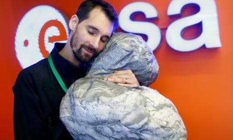 ESA staff member Mattial Malmer rests his head against a model of comet 67P/ Churyumov-Gerasimenko, target for the Rosetta mission, which ended today.