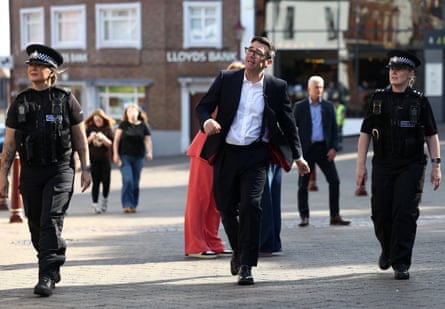 Burnha walks through Ilkeston town centre with police officers on either side