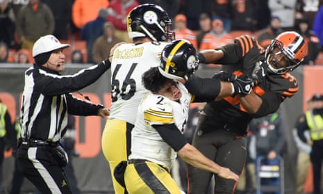 Browns defensive end Myles Garrett (95) hits Steelers quarterback Mason Rudolph (2) with a helmet near the end of Thursday night’s game in Cleveland.