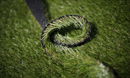 Close up on roll of artificial turf being cut