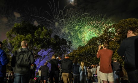 La gente ve los fuegos artificiales a las 9 p.m. en el Jardín Botánico de Sydney durante la celebración de la víspera de Año Nuevo el 31 de diciembre de 2022 en Sydney, Australia.