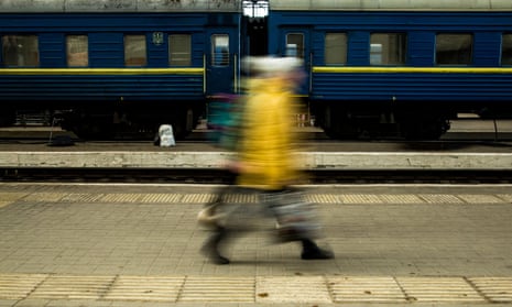 A blurred pic of people walking along a railway platform