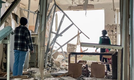 Two people stand inside a devastated room in a damaged hospital in Kherson, Ukraine, 28 March 2023.